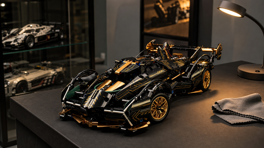 Black and gold V12 RC building block supercar on a collector display plinth under an inspection lamp